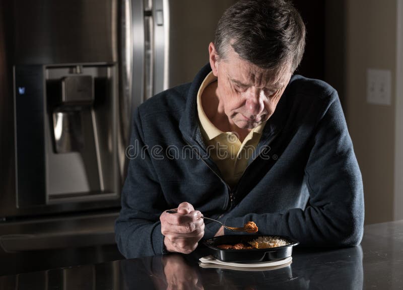 Pasto pronto mangiatore di uomini senior solo alla tavola fotografie stock libere da diritti Pasto pronto mangiatore di uomini senior solo alla tavola fotografie stock libere da diritti
