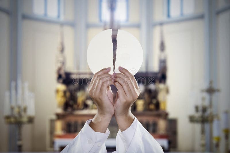 Pastor hands split a communion bread in church