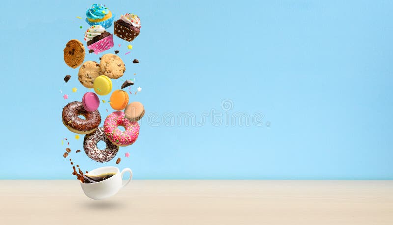 Donuts, cupcakes, cookies, macaroons and coffee cup flying over blue background. . Sweetshop and coffeeshop concept background.