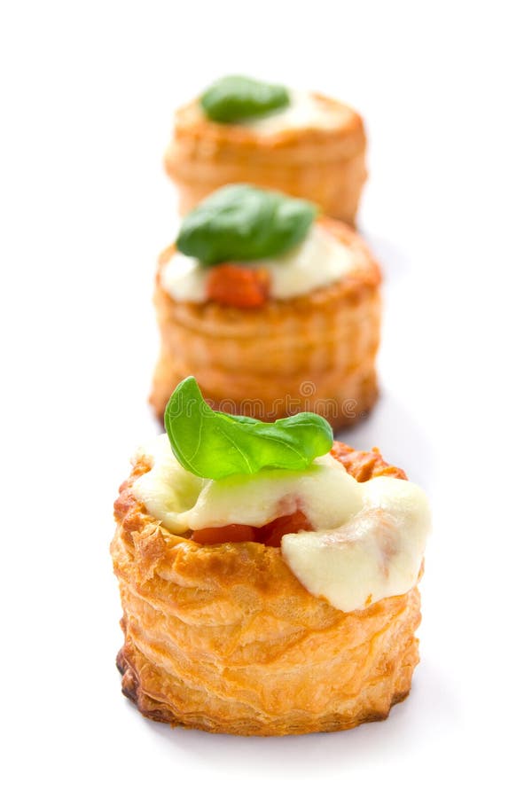 Tres soplar pasteles relleno tomates respaldado queso triunfo albahaca hojas en línea.