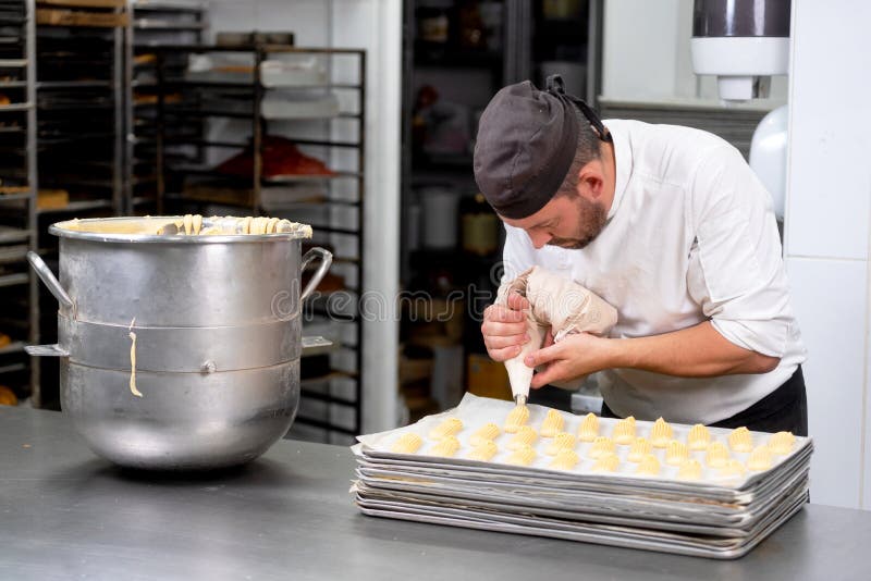 Pastry Chef with Confectionary Bag Squeezing Cream at Pastry Shop