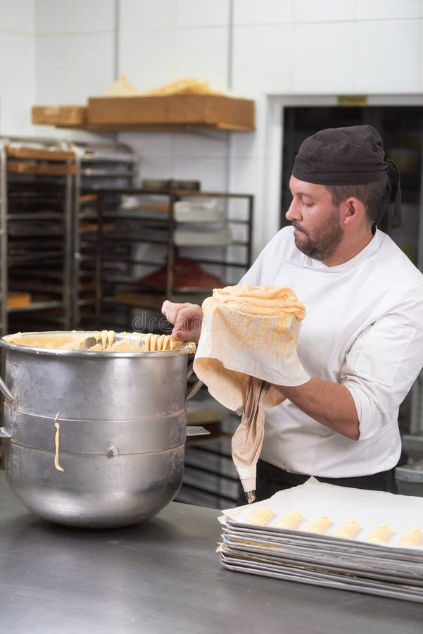 Pastry Chef with Confectionary Bag Squeezing Cream at Pastry Shop