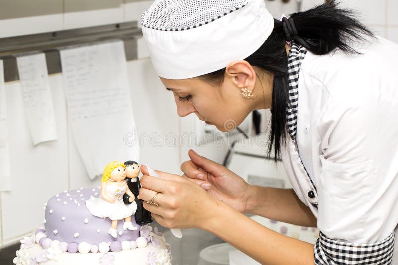 Pastry chef decorates a cake