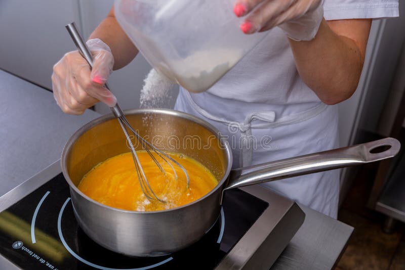 The Chef Mixes the Sauce in a Saucepan Using the Whisk. Master