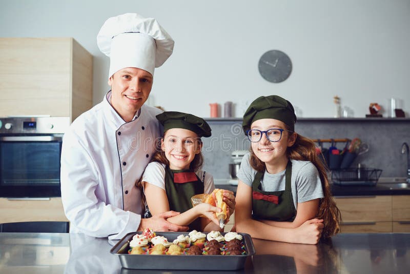 Pastry-cook with girls children prepare cookies in the kitchen. royalty free stock photo Pastry-cook with girls children prepare cookies in the kitchen. royalty free stock photo