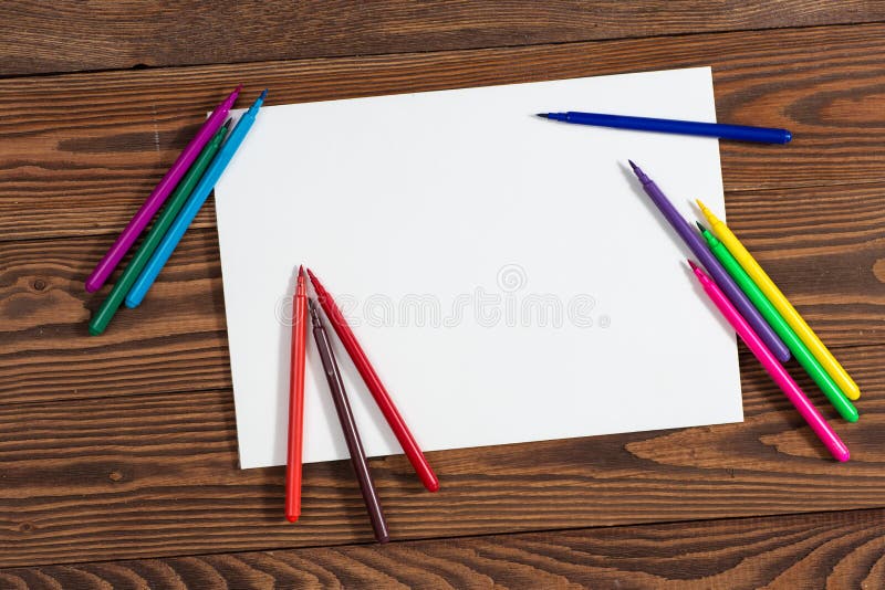 Pastéis coloridos e uma folha de papel a madeira do caderno fotografia de stock Pastéis coloridos e uma folha de papel a madeira do caderno fotografia de stock