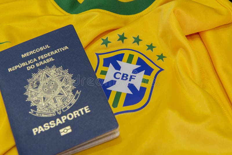 Bauru, Brazil - 11.01.23: Brazilian Football Confederation emblem on football jersey. Soccer players sale and trading concept. Passport and money from fans or players on the Brazilian team t-shirt. Bauru, Brazil - 11.01.23: Brazilian Football Confederation emblem on football jersey. Soccer players sale and trading concept. Passport and money from fans or players on the Brazilian team t-shirt