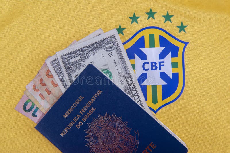 Bauru, Brazil - 11.01.23: Brazilian Football Confederation emblem on football jersey. Soccer players sale and trading concept. Passport and money from fans or players on the Brazilian team t-shirt. Bauru, Brazil - 11.01.23: Brazilian Football Confederation emblem on football jersey. Soccer players sale and trading concept. Passport and money from fans or players on the Brazilian team t-shirt