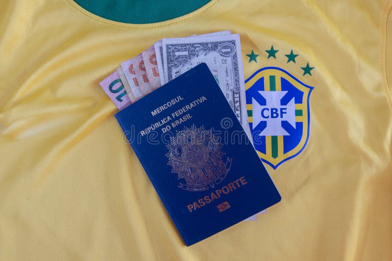 Bauru, Brazil - 11.01.23: Brazilian Football Confederation emblem on football jersey. Soccer players sale and trading concept. Passport and money from fans or players on the Brazilian team t-shirt. Bauru, Brazil - 11.01.23: Brazilian Football Confederation emblem on football jersey. Soccer players sale and trading concept. Passport and money from fans or players on the Brazilian team t-shirt