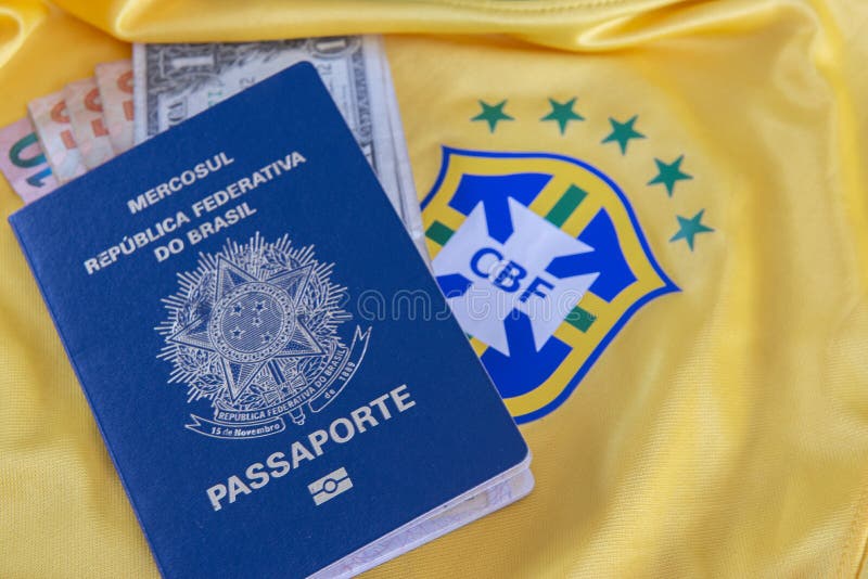 Bauru, Brazil - 11.01.23: Brazilian Football Confederation emblem on football jersey. Soccer players sale and trading concept. Passport and money from fans or players on the Brazilian team t-shirt. Bauru, Brazil - 11.01.23: Brazilian Football Confederation emblem on football jersey. Soccer players sale and trading concept. Passport and money from fans or players on the Brazilian team t-shirt