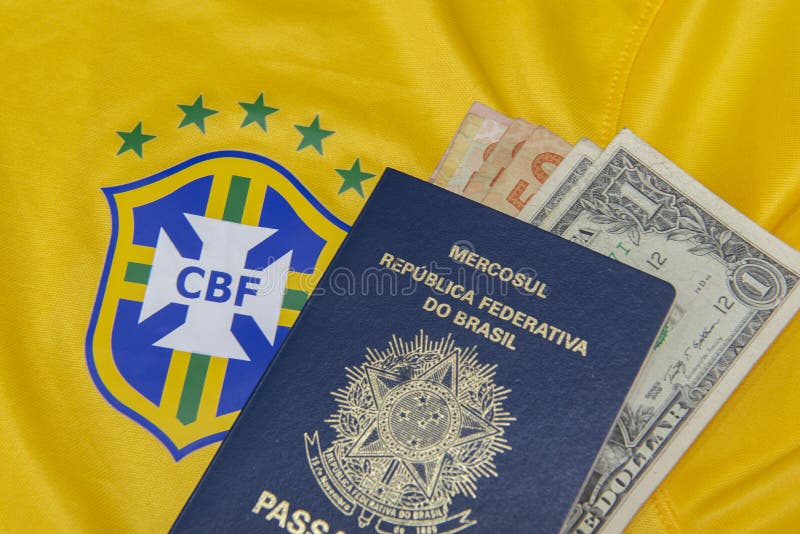 Bauru, Brazil - 11.01.23: Brazilian Football Confederation emblem on football jersey. Soccer players sale and trading concept. Passport and money from fans or players on the Brazilian team t-shirt. Bauru, Brazil - 11.01.23: Brazilian Football Confederation emblem on football jersey. Soccer players sale and trading concept. Passport and money from fans or players on the Brazilian team t-shirt