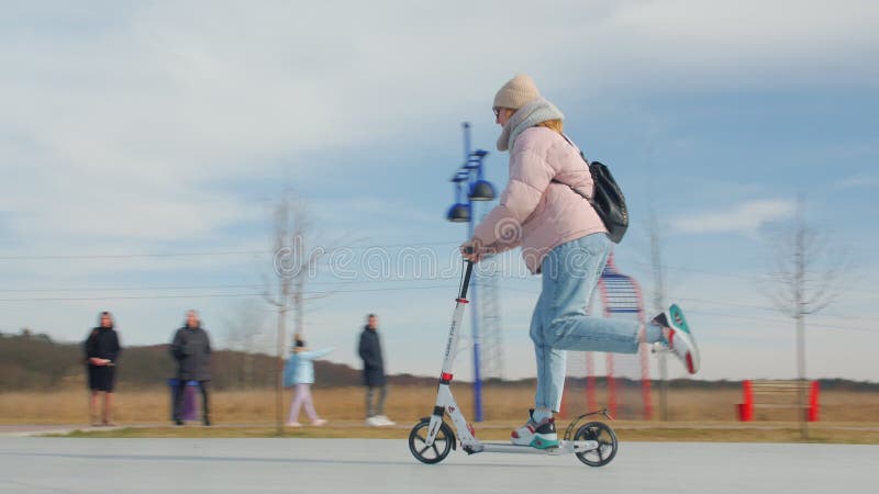 Patada scooter joven mujer parque