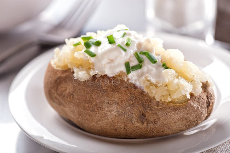 A delicious oven baked potato with sour cream and chives. A delicious oven baked potato with sour cream and chives.