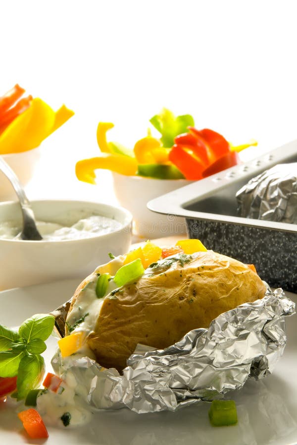 Tasty baked potato with sour cream, herbs and pepper. Tasty baked potato with sour cream, herbs and pepper.