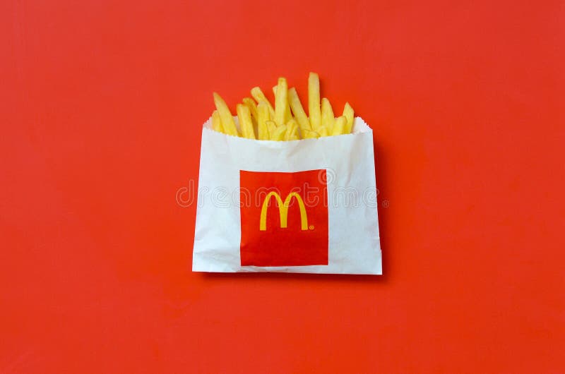 Patatas fritas de mcdonald en pequeña bolsa de papel en fondo rojo brillante imagen de archivo libre de regalías Patatas fritas de mcdonald en pequeña bolsa de papel en fondo rojo brillante imagen de archivo libre de regalías