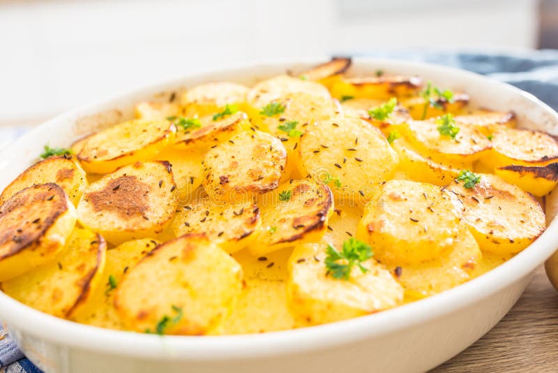 Patate arrostite con le spezie e le erbe sul tavolo da cucina fotografie stock Patate arrostite con le spezie e le erbe sul tavolo da cucina fotografie stock