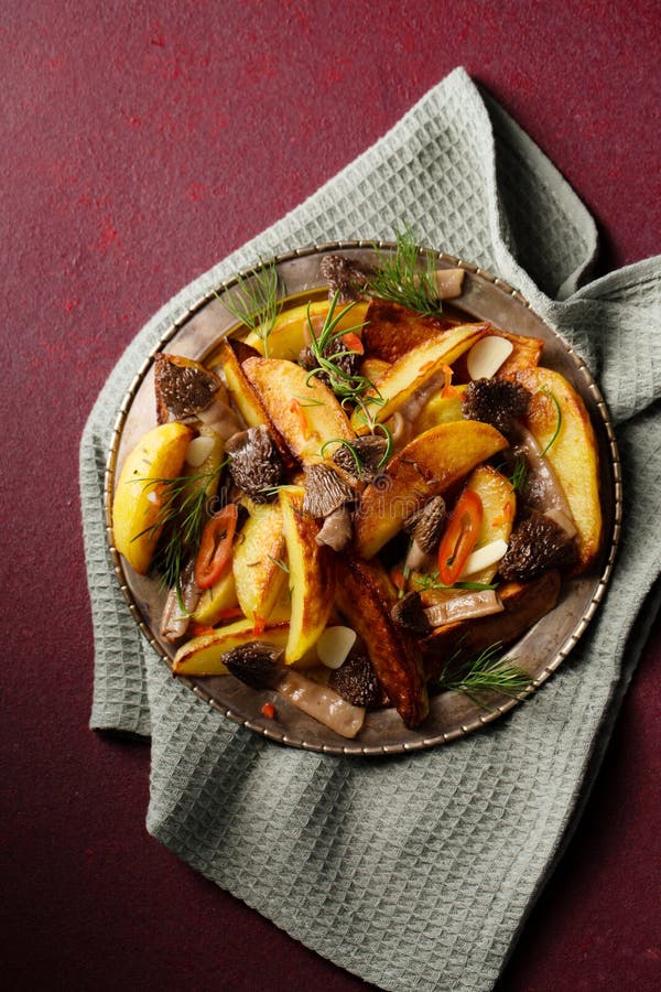 Patate con funghi selvatici Morel condite con aglio e verdi di chilli immagine stock libera da diritti