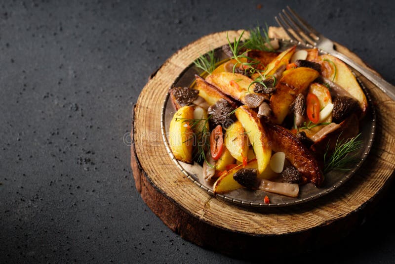Patate di consumo con funghi selvatici di patate condite con peperoncino e aglio fotografia stock