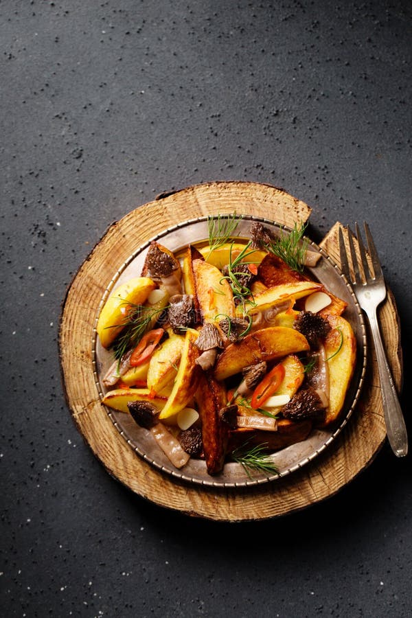 Patate di consumo con funghi selvatici di patate condite con peperoncino e verdure fotografia stock