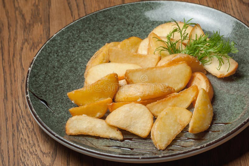 Patate fritte in stile contadino con un'anatra in un piatto immagini stock libere da diritti