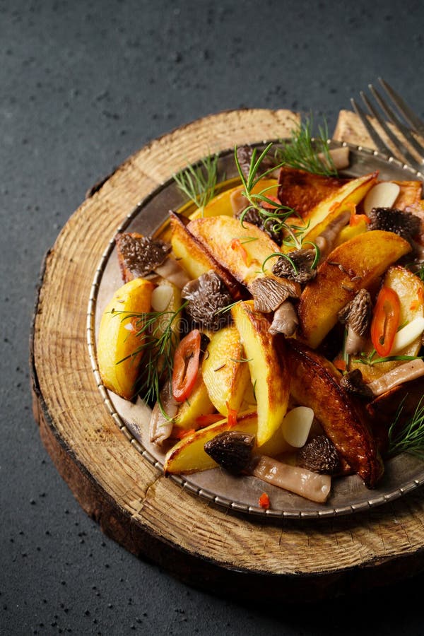 Patate in stile contadino con funghi selvatici, di condimenti con aglio e verdure fotografia stock libera da diritti