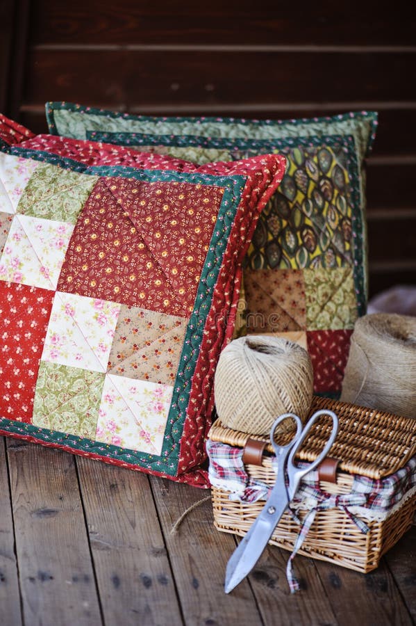 Μαξιλάρια patchwork χειροποίητα με εργαλεία ραπτικής σε ένα ξύλινο τραπέζι στοκ φωτογραφία