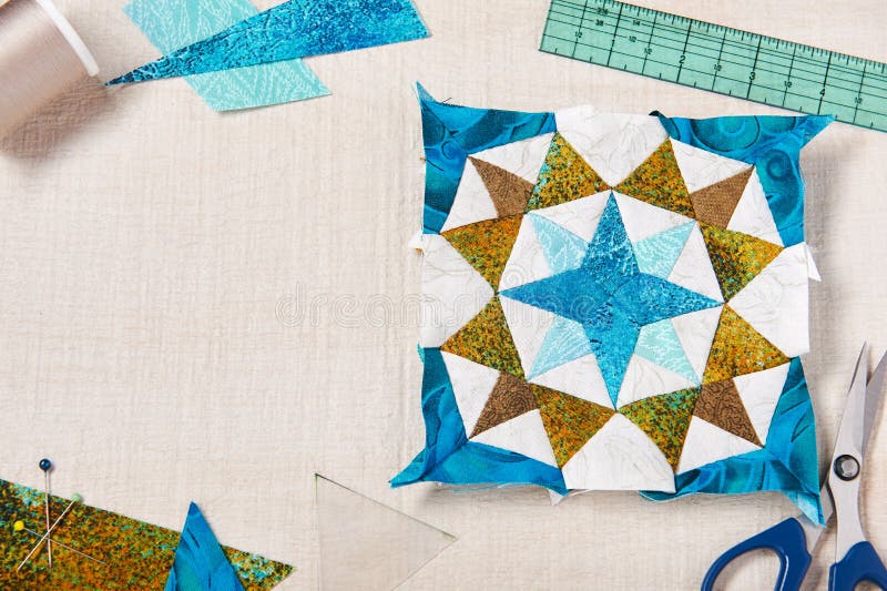 Patchwork Block and Sewing Accessories on White Wooden Surface Stock