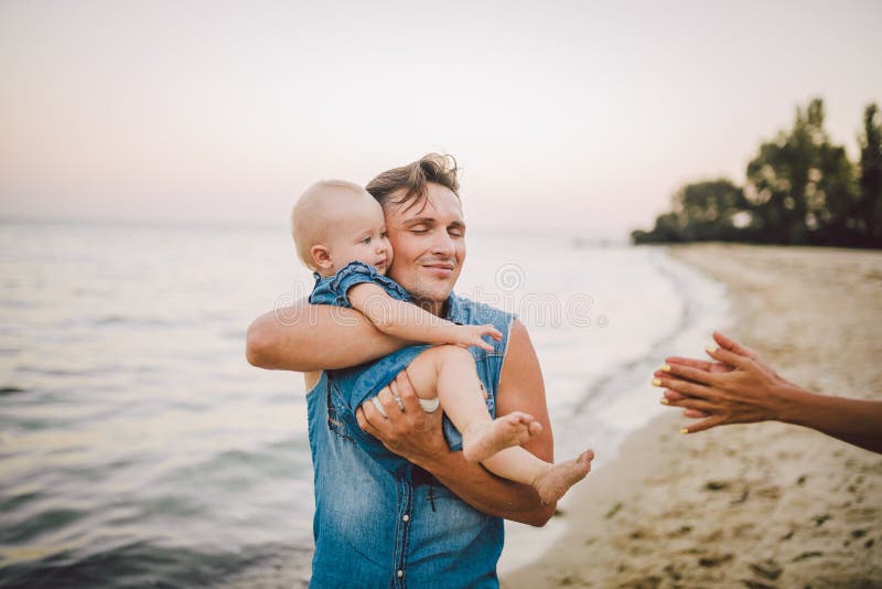 Paternidad y resto del tema con un ni?o en el mar El padre cauc?sico hermoso joven juega juegos goza el lanzar para arriba en bra fotografía de archivo libre de regalías Paternidad y resto del tema con un ni?o en el mar El padre cauc?sico hermoso joven juega juegos goza el lanzar para arriba en bra fotografía de archivo libre de regalías