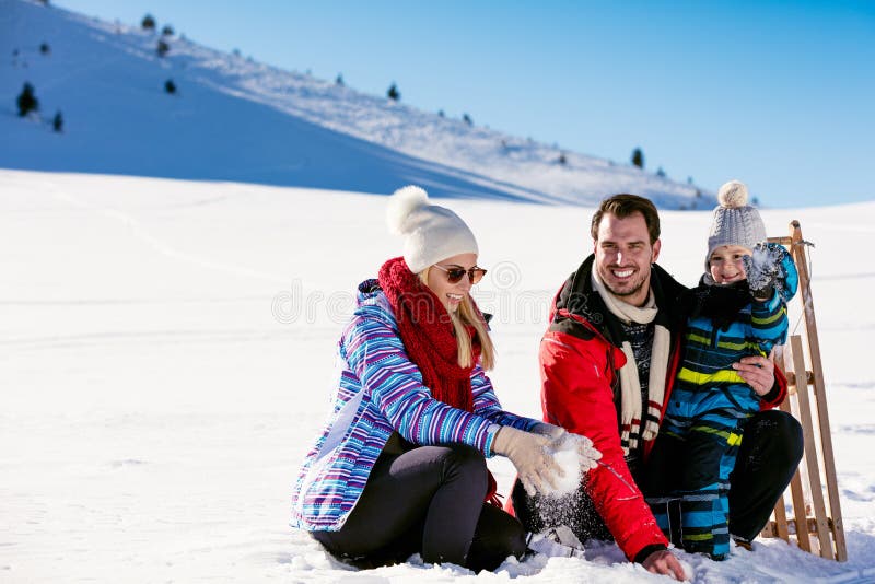 Paternità, modo, stagione e concetto della gente - famiglia felice con il bambino sulla slitta che cammina nell'inverno all'apert fotografia stock Paternità, modo, stagione e concetto della gente - famiglia felice con il bambino sulla slitta che cammina nell'inverno all'apert fotografia stock