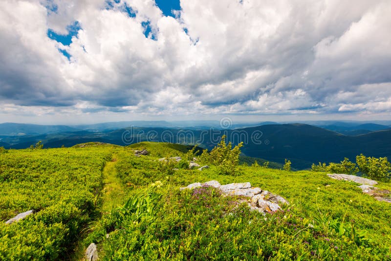 Path along the grassy slope on top of a mountain. Lovely summer landscape. wonderful place for hiking and camping. cloudy sky above the mountain ridge in the stock photo Path along the grassy slope on top of a mountain. Lovely summer landscape. wonderful place for hiking and camping. cloudy sky above the mountain ridge in the stock photo