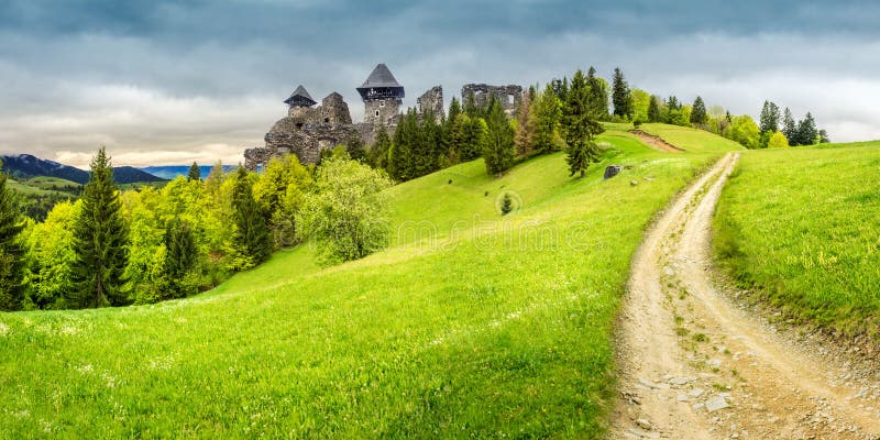 Path to fortress ruins on hillside with forest