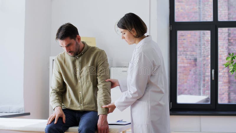 Patient, der dem Arzt eine Armverletzung zeigte