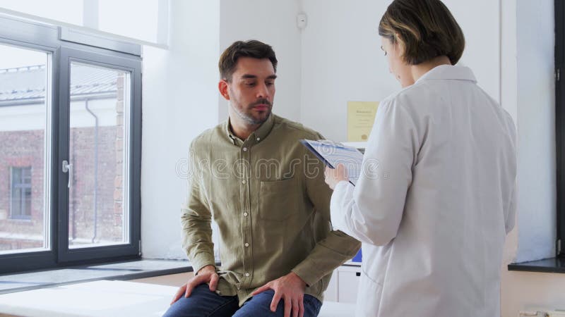 Patient, der dem Arzt im Krankenhaus eine Zwischenablage gibt