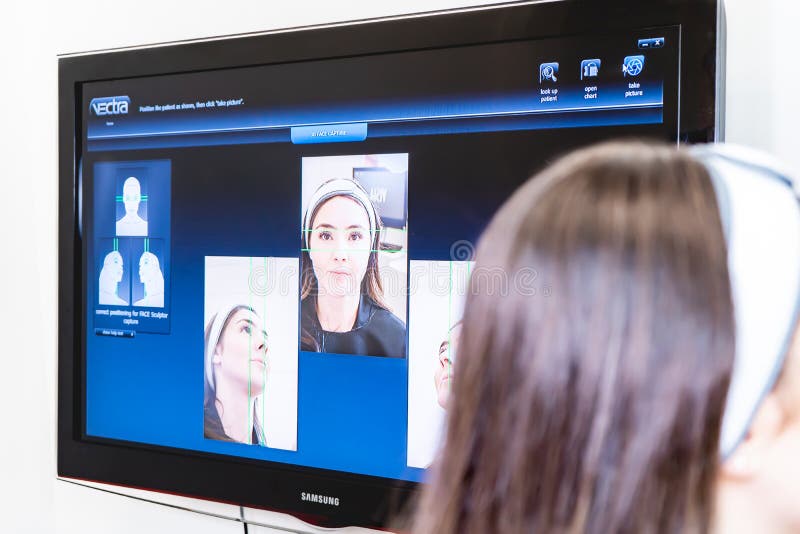 Patient sitting for Vectra 3D imaging scan, in a beauty laser clinic, for tracking procedure results with digital analysis.