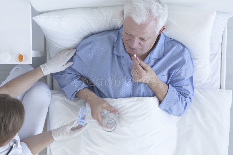 Patient taking pill with glass of water