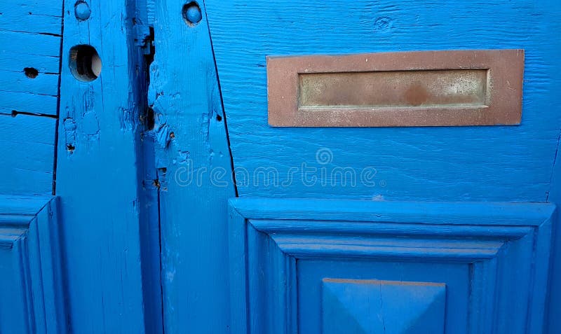 Patina-Messingpost-Schlitz in beunruhigter blauer Holztür lizenzfreies stockfoto