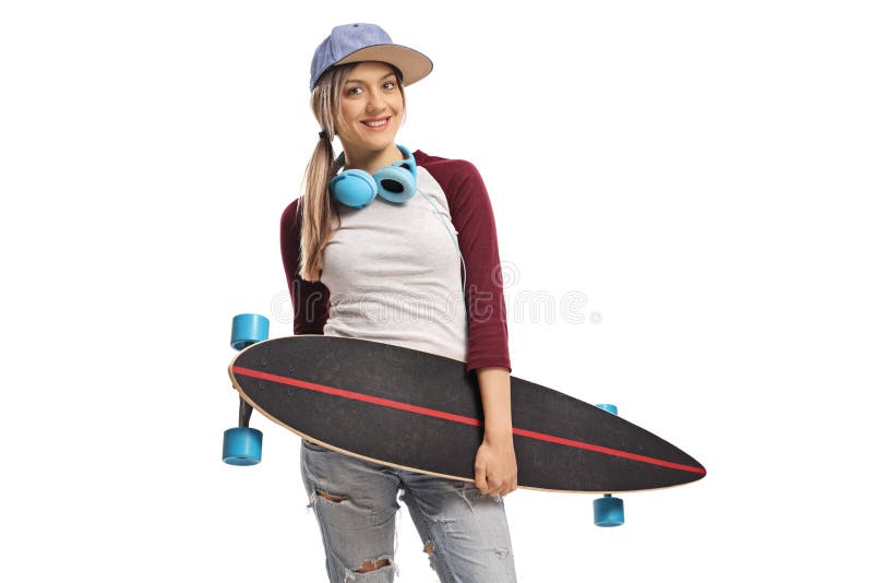 Patinador de sexo femenino con un longboard y una sonrisa de los auriculares imágenes de archivo libres de regalías Patinador de sexo femenino con un longboard y una sonrisa de los auriculares imágenes de archivo libres de regalías