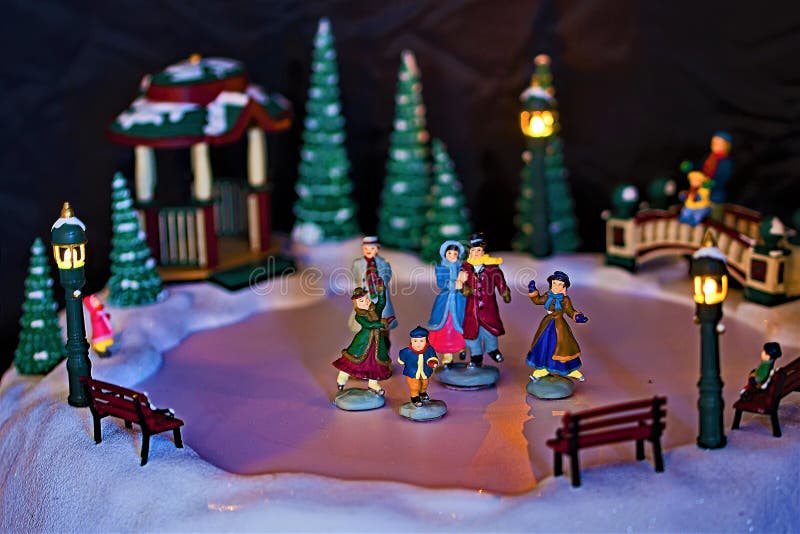Patinadores miniatura del invierno con el fondo oscuro fotos de archivo Patinadores miniatura del invierno con el fondo oscuro fotos de archivo