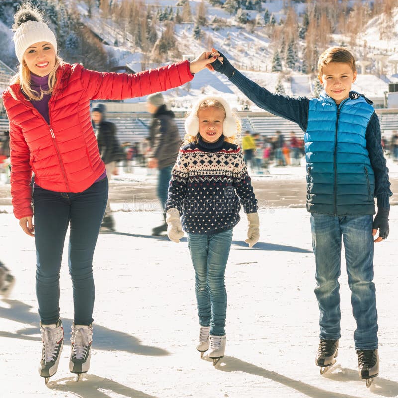 Patinaje de hielo al aire libre de la familia feliz en la pista Actividades del invierno fotografía de archivo Patinaje de hielo al aire libre de la familia feliz en la pista Actividades del invierno fotografía de archivo