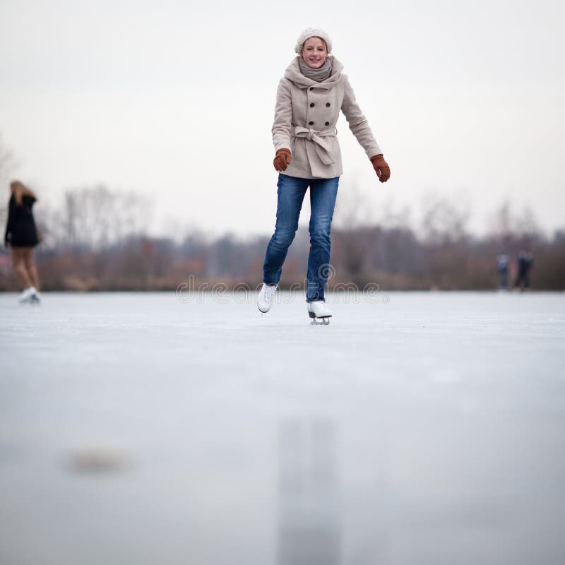 Patinaje de hielo de la mujer joven al aire libre en una charca fotos de archivo libres de regalías Patinaje de hielo de la mujer joven al aire libre en una charca fotos de archivo libres de regalías