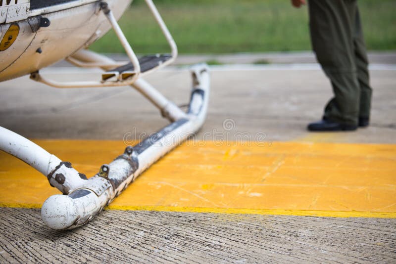 Patins de aterrissagem do helicóptero no backgroun do heliporto e do piloto fotos de stock royalty free Patins de aterrissagem do helicóptero no backgroun do heliporto e do piloto fotos de stock royalty free
