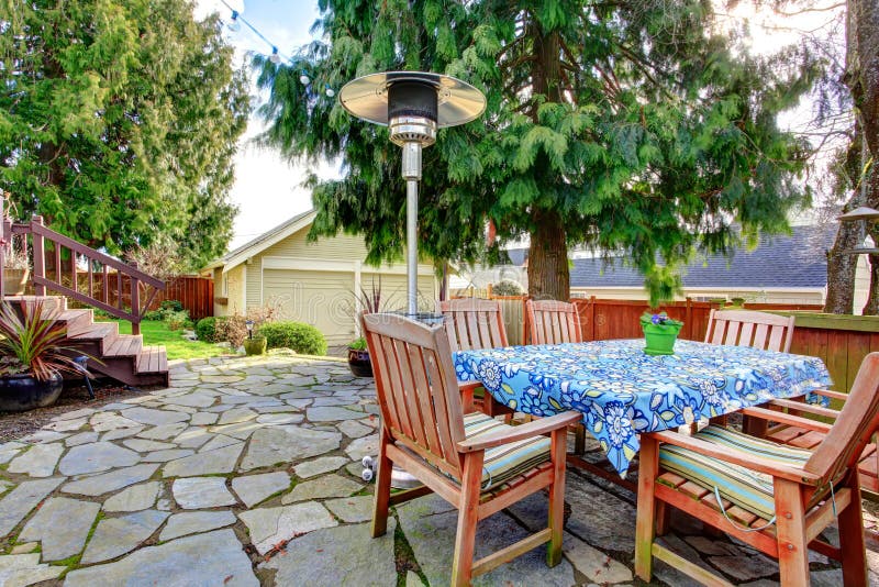 Stoned patio area with wood dining table set, heat lamp. Stoned patio area with wood dining table set, heat lamp