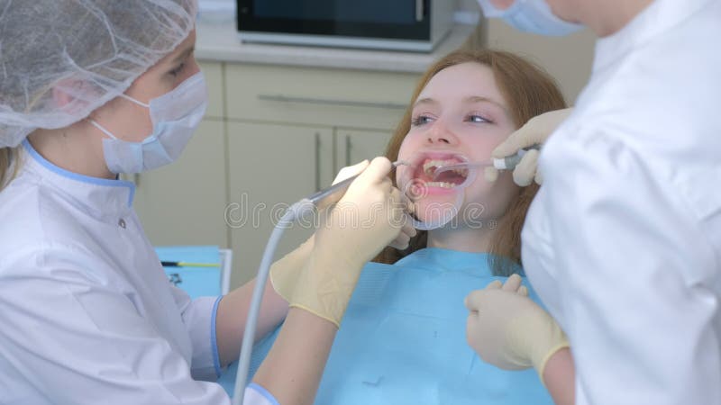 Patiëntenvrouw over hygiënische reiniging van tanden in de tandheelkunde door tandarts.