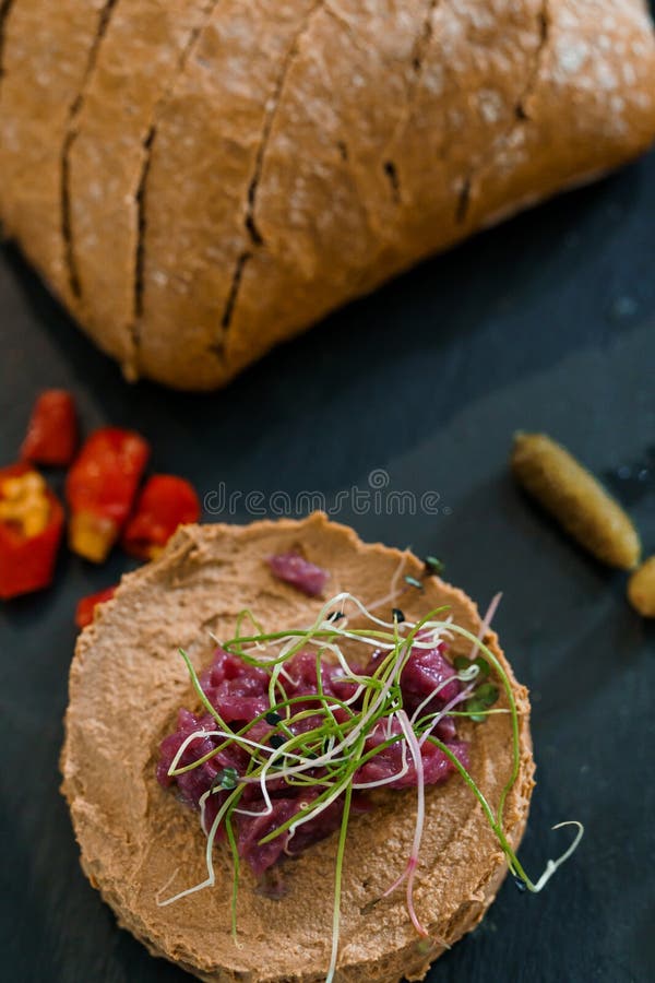 Pato salado de hígado de pollo con microvegetales frescos y acompañamientos en pizarra foto de archivo