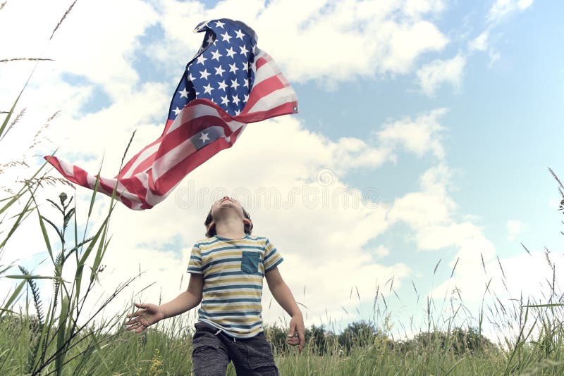 Patriotic holiday.Young boy with American flag.USA celebrate 4th of July. 