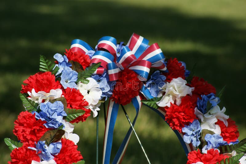 Close view of top of memorial wreath of flowers decorated in the colors of the American flag. Close view of top of memorial wreath of flowers decorated in the colors of the American flag.