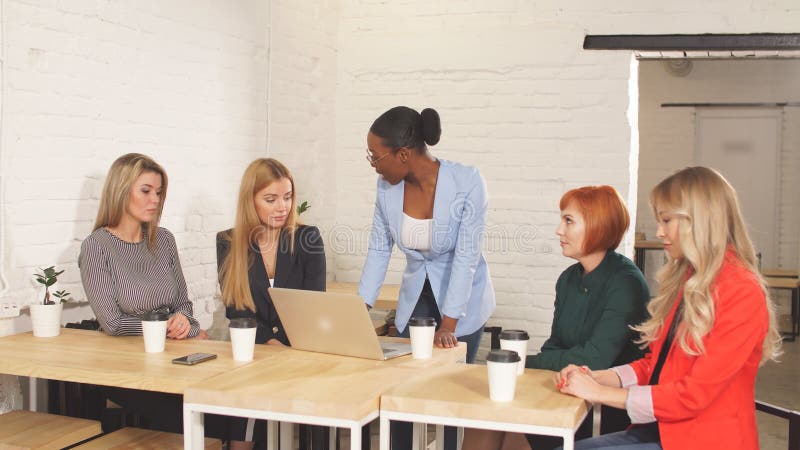 Patron femelle africain indiquant outre de ses employés féminins, s'asseyant dans le lieu de réunion clips vidéos