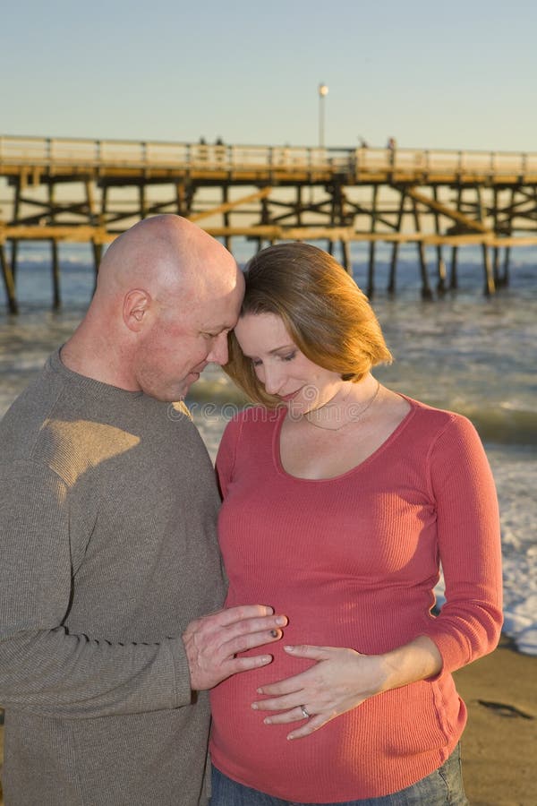 Young Pregnant couple on the Beach at Sunset. Young Pregnant couple on the Beach at Sunset