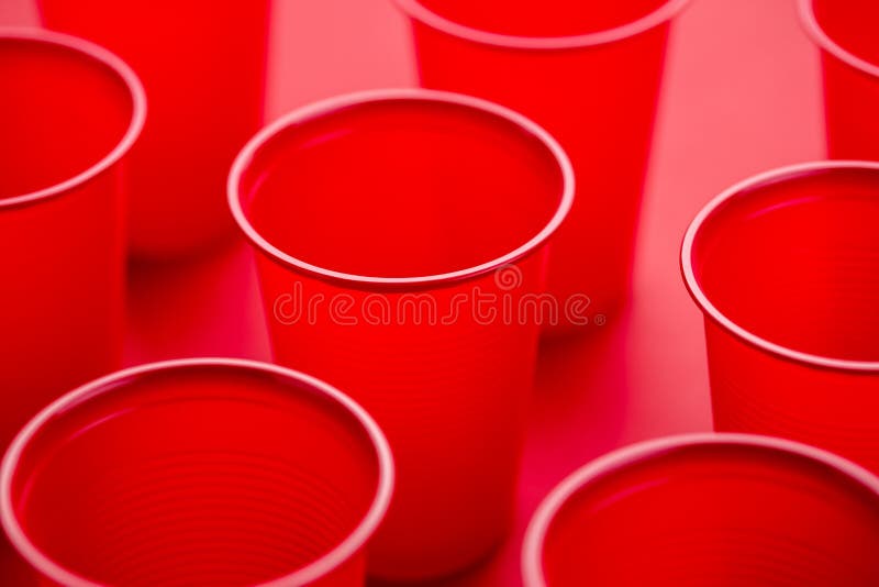 Pattern of Drinking Plastic Disposable Glasses on a Red Background