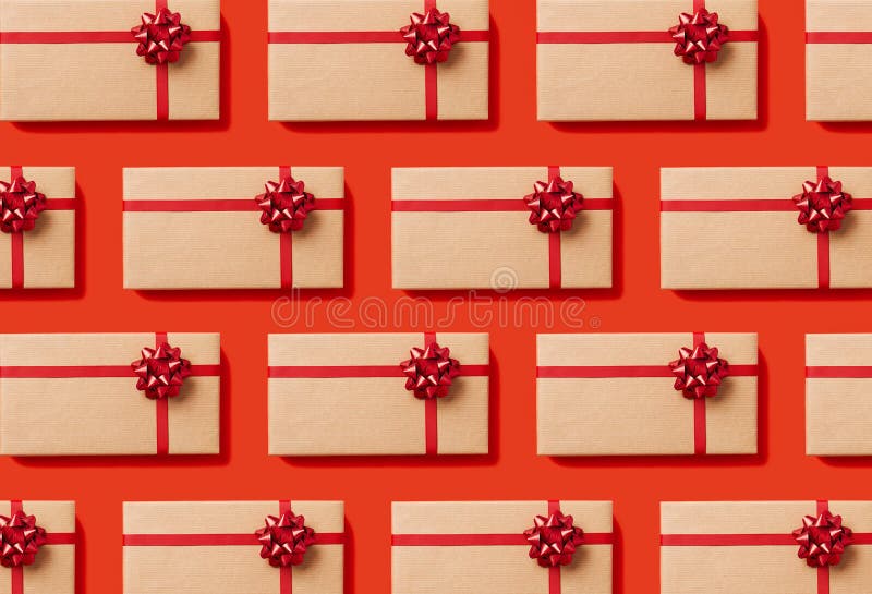 Overhead view of seamless pattern of Christmas gift boxes wrapped in craft paper with a red bow on red background. Seamless bow stock images, royalty-free photos and pictures